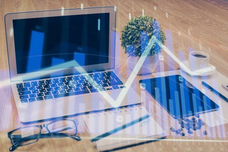Financial chart drawing and table with computer on background. Multi exposure. Concept of international markets.の写真素材