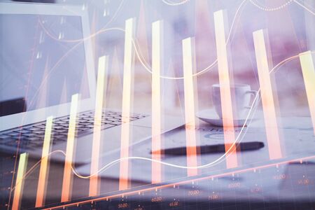 Forex graph hologram on table with computer background. Double exposure. Concept of financial markets.の写真素材