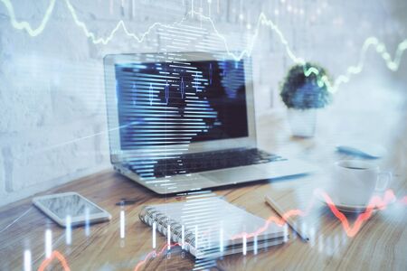 Stock market graph on background with desk and personal computer. Double exposure. Concept of financial analysis.の写真素材