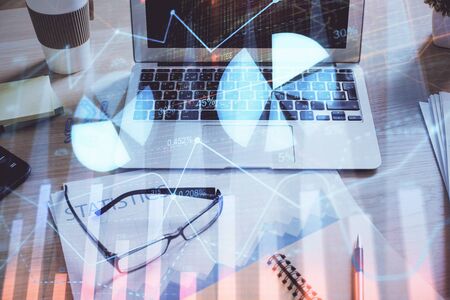 Financial market graph hologram and personal computer on background. Double exposure. Concept of forex.の写真素材