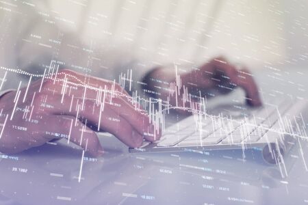 Double exposure of graph with man typing on computer in office on background. Concept of hard work.