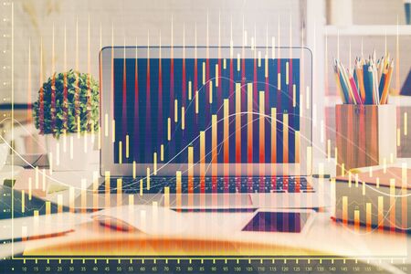 Financial graph colorful drawing and table with computer on background. Double exposure. Concept of international markets.の写真素材