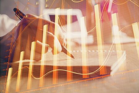 Financial charts displayed on woman's hand taking notes background. Concept of research. Double exposureの写真素材