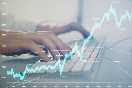Forex graph with businessman working on computer in office on background. Concept of hardworking....
