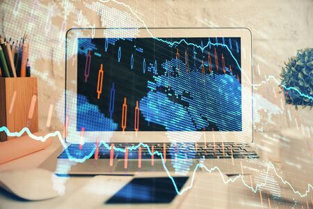 Forex market graph hologram and personal computer on background. Double exposure. Concept of investment.の写真素材