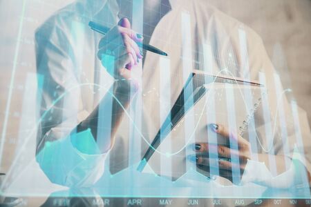 Financial chart drawn over hands taking notes background. Concept of research. Multi exposureの写真素材