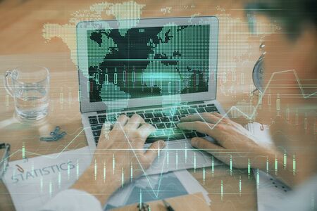 Multi exposure of market chart with man working on computer on background. Concept of financial...