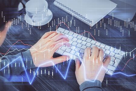 Multi exposure of graph with man typing on computer in office on background. Concept of hard work.