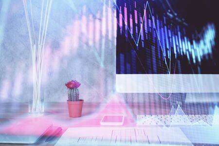 Forex graph hologram on table with computer background. Multi exposure. Concept of financial markets.の写真素材