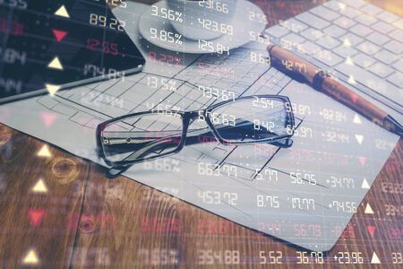 Financial chart hologram with glasses on the table background. Concept of business. Double exposure.の写真素材