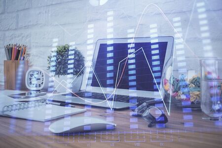 Forex market graph hologram and personal computer on background. Double exposure. Concept of investment.の写真素材