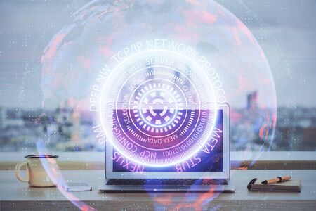 Computer on desktop in office with technology theme hologram. Multi exposure. Tech concept.の写真素材