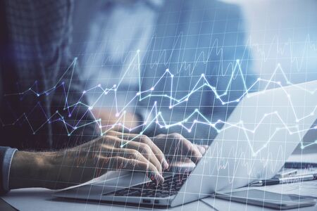 Double exposure of market chart with man working on computer on background. Concept of financial...