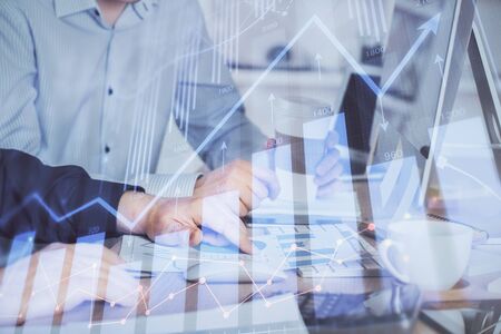 Multi exposure of chart with man typing on computer in office on background. Concept of hard work.の写真素材