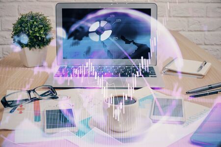 Financial chart drawing and table with computer on background. Double exposure. Concept of international markets.の写真素材