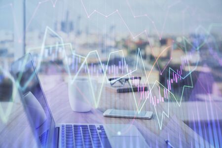 Stock market graph on background with desk and personal computer. Double exposure. Concept of financial analysis.の写真素材