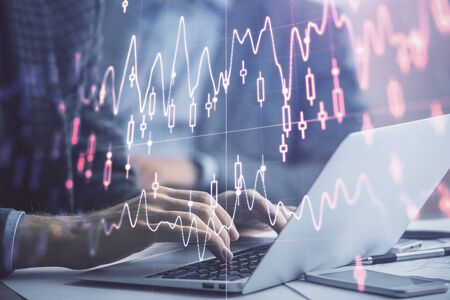 Double exposure of market chart with man working on computer on background. Concept of financial...