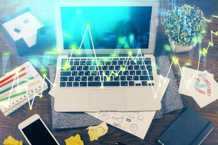 Double exposure of graph and financial info and work space with computer background. Concept of international online trading.の写真素材