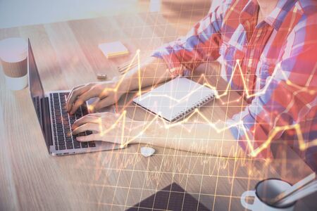 Multi exposure of forex graph with man working on computer on background. Concept of market...