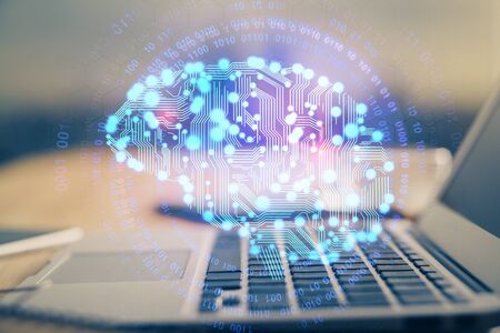 Double exposure of table with computer and brain hologram. Data innovation concept.