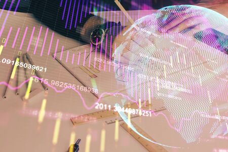 Double exposure of mans hands writing notes of stock market with forex graph background. Concept of research and trading.の写真素材