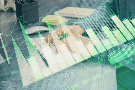 Stock graph with businessman typing on computer in office on background. Concept of analysis. Double exposure.の写真素材