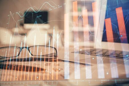 Financial chart hologram with glasses on the table background. Concept of business. Double exposure.の写真素材