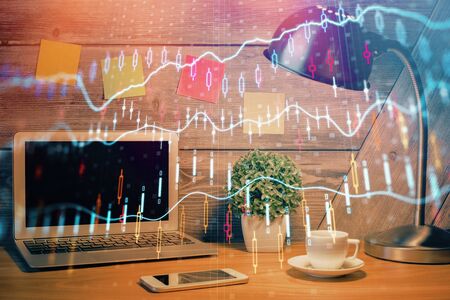 Double exposure of graph and financial info and work space with computer background. Concept of international online trading.の写真素材