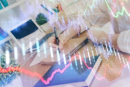 Financial graph displayed on womans hand taking notes background. Concept of research. Double...