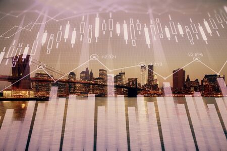 Financial graph on night city scape with tall buildings background double exposure. Analysis concept.の写真素材