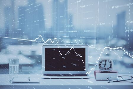 Stock market graph on background with desk and personal computer. Double exposure. Concept of financial analysis.の写真素材