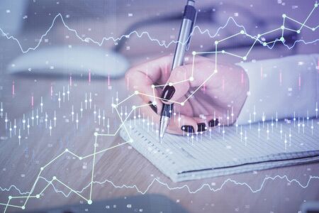 Multi exposure of hands making notes with forex chart huds. Stock market concept.の写真素材