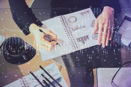 Multi exposure of hands making notes with forex chart huds. Stock market concept.の写真素材
