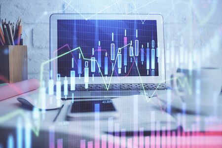 Stock market graph on background with desk and personal computer. Double exposure. Concept of financial analysis.の写真素材