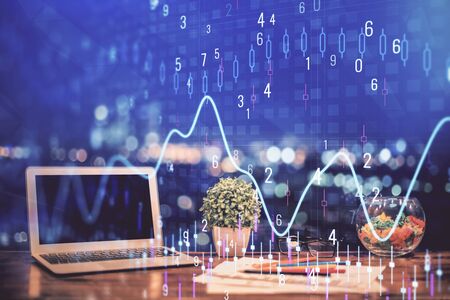 Forex graph hologram on table with computer background. Double exposure. Concept of financial markets.の写真素材