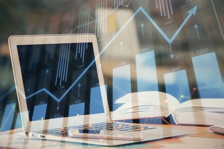 Forex graph hologram on table with computer background. Double exposure. Concept of financial...