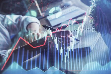 Financial forex charts displayed on womans hand taking notes background. Concept of research. Double...