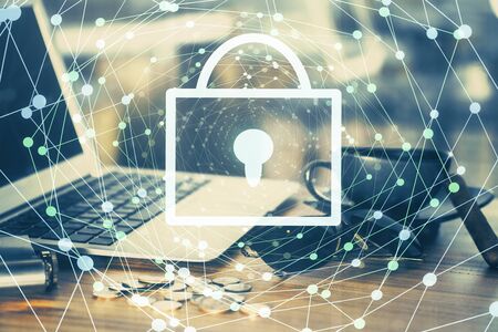 Double exposure of desktop with computer and lock icon hologram. Concept of data safety.