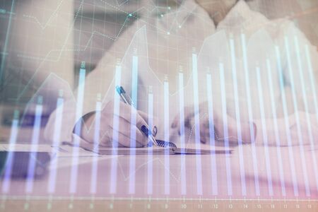 Financial chart drawn over hands taking notes background. Concept of research. Multi exposureの写真素材