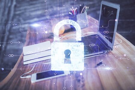 Double exposure of desktop with computer and lock icon hologram. Concept of data safety.