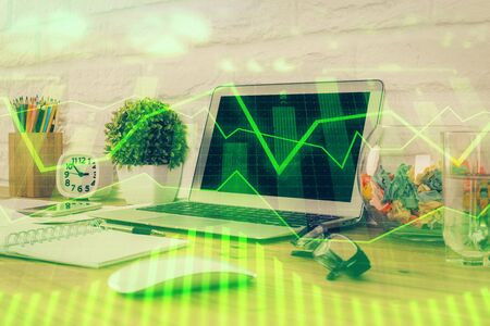 Financial graph colorful drawing and table with computer on background. Multi exposure. Concept of international markets.の写真素材