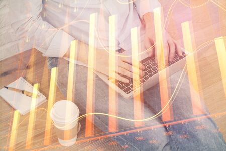 Forex graph with businessman working on computer in office on background. Concept of analysis. Double exposure.の写真素材