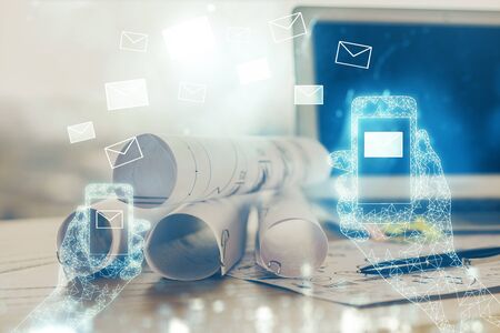 Desktop computer background in office and flying envelops hologram drawing. Multi exposure. Electronic mail concept.の写真素材