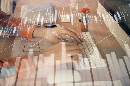 Double exposure of stock market chart with man working on computer on background. Concept of...