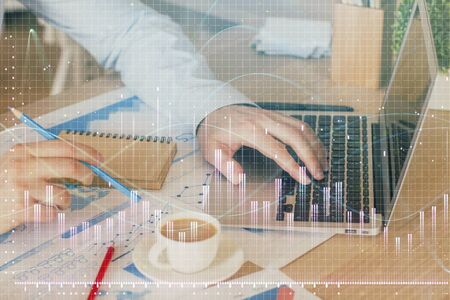 Forex graph with businessman working on computer in office on background. Concept of hardworking....