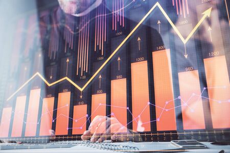 Forex graph with businessman typing on computer in office on background. Concept of analysis. Double...