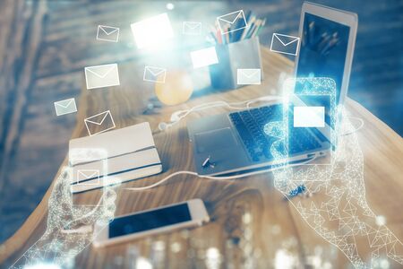 Desktop computer background in office and flying envelops hologram drawing. Multi exposure. Electronic mail concept.の写真素材