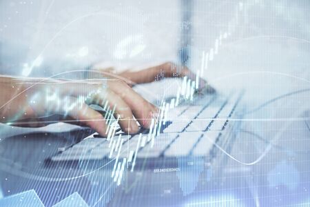 Forex graph with businessman working on computer in office on background. Concept of hardworking....