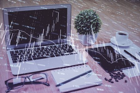 Financial graph colorful drawing and table with computer on background. Double exposure. Concept of international markets.の写真素材