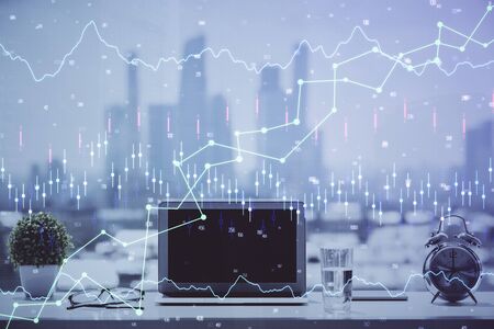 Stock market graph on background with desk and personal computer. Multi exposure. Concept of financial analysis.の写真素材